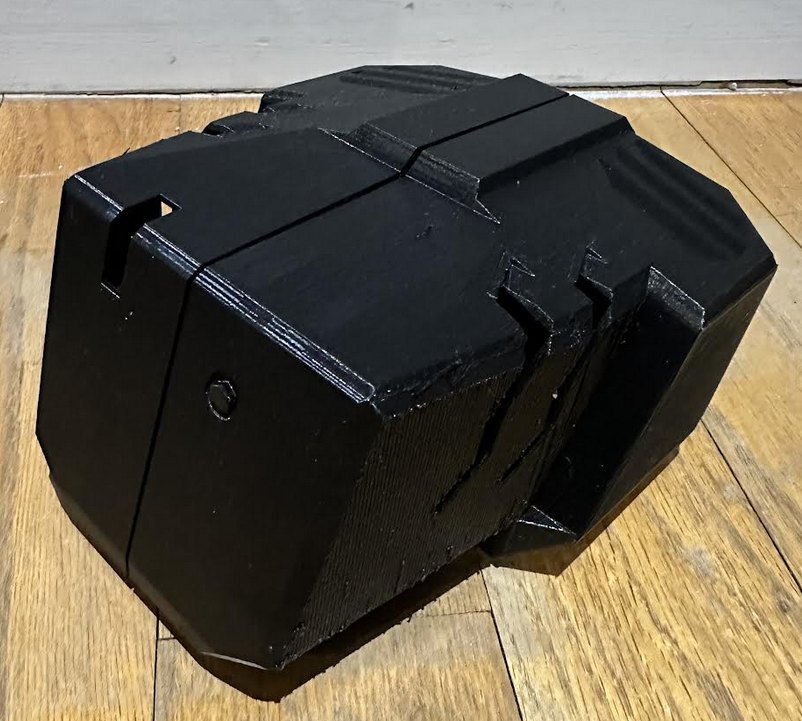 A bulky black 3D-printed shell shaped like an angular pod.